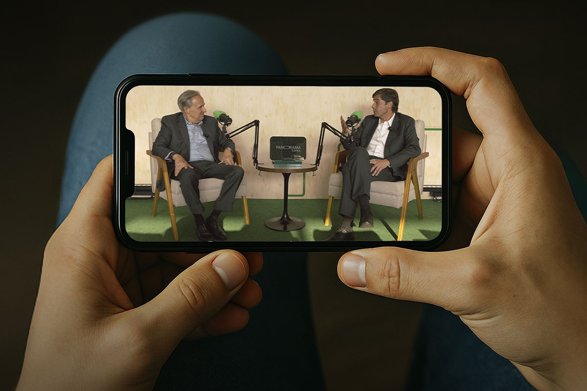 Pessoa segura um celular e assiste ao Panorama Talks #7